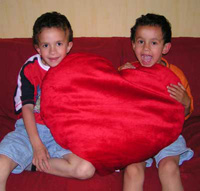 Gabriƫl & Tiago, holding a red heart-shaped pillow